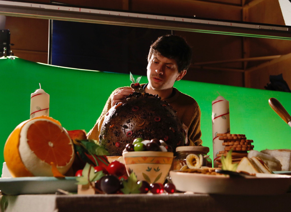 Director Dan Ojari puts the finishing touches on a set designed as an English Christmas feast. (Aardman Animations)